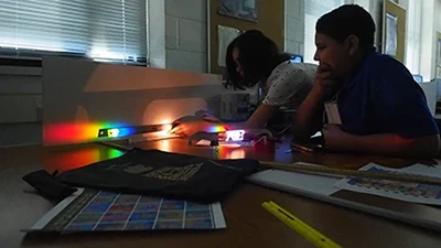 These students are analyzing the light coming from a laser to determine its wavelength.